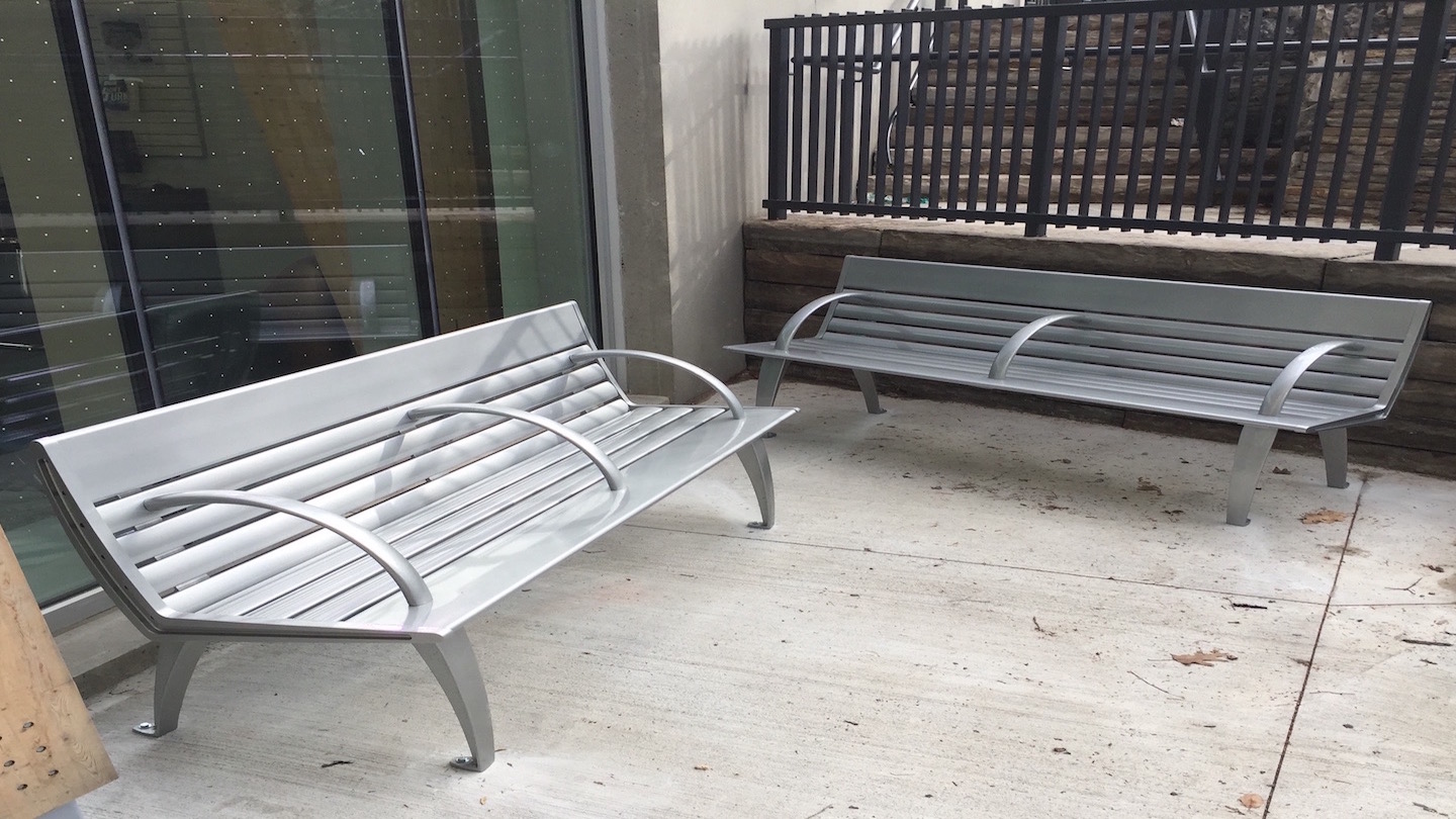 Custom outdoor benches installed on a sidewalk.