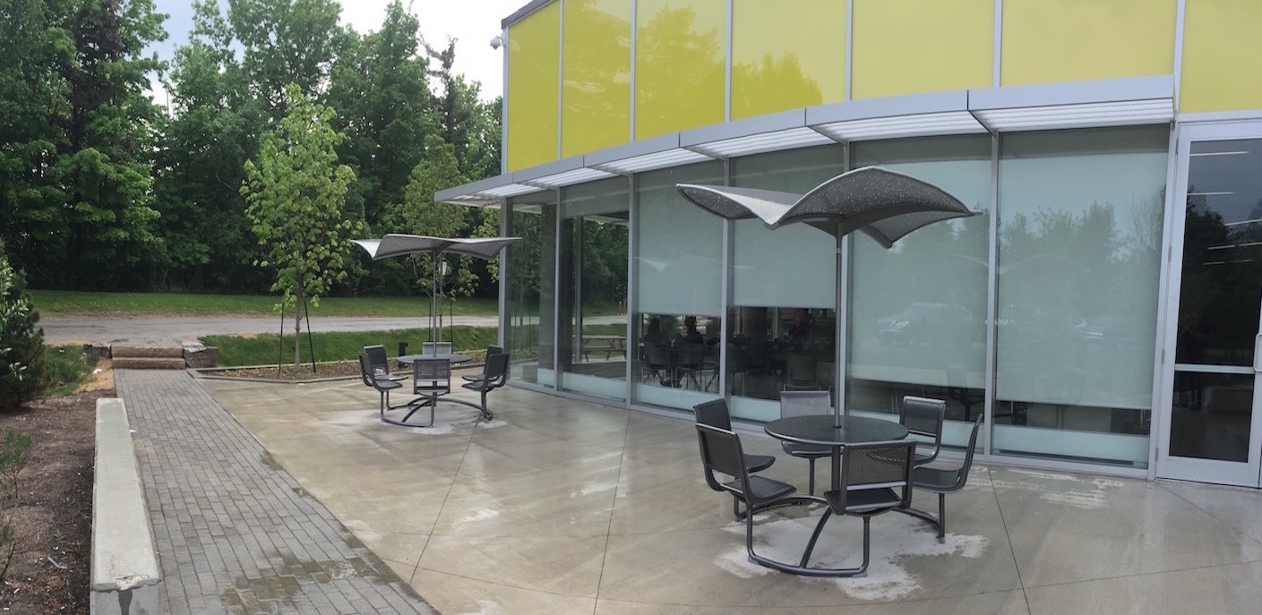 Outdoor patio sets installed behind a building.